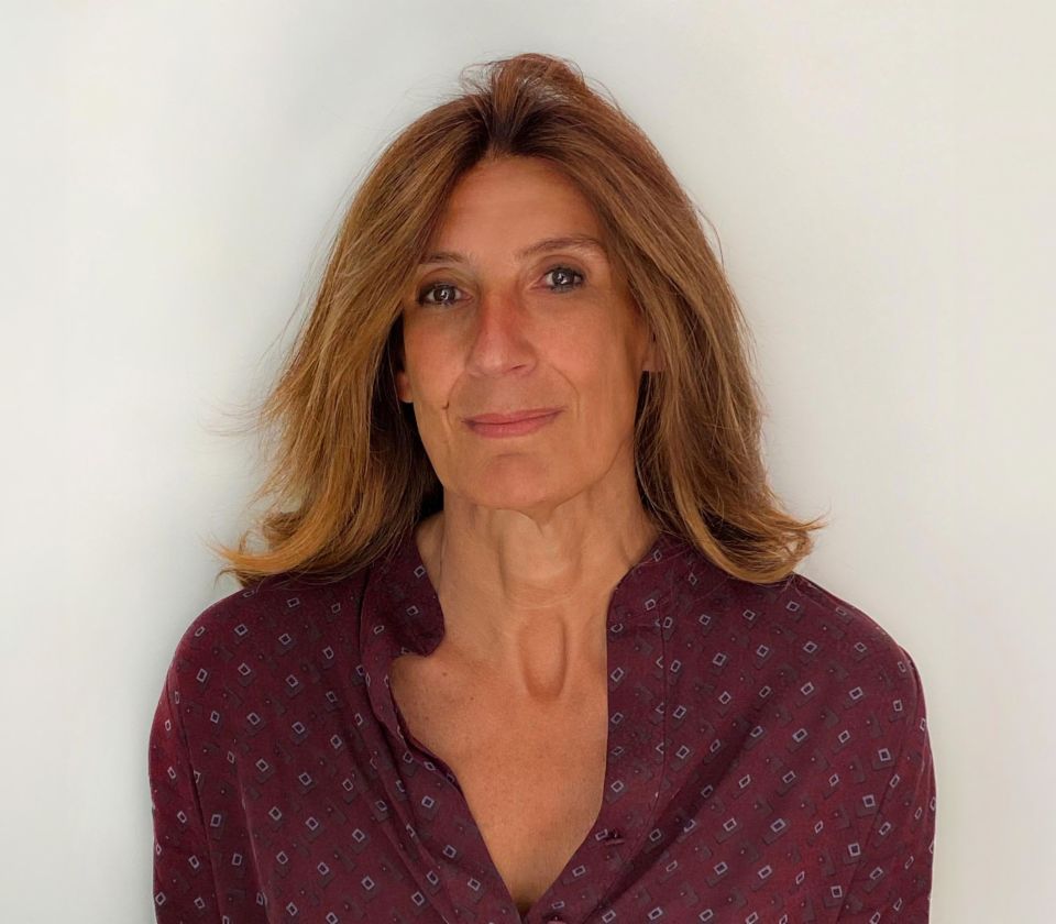 Portrait de Nathalie Lameyre, debout dans une pièce lumineuse