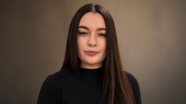 Daniela Moaca, Senior Manager IT chez EOS Romania, photo de portrait en pull à col roulé sombre.