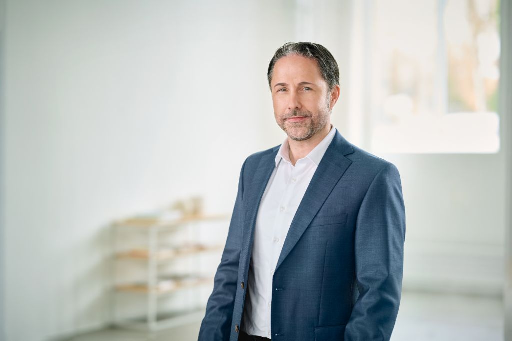 Portrait de Marwin Ramcke, président du conseil d’administration du Groupe EOS, dans une pièce lumineuse, vêtu d’un blazer sombre 