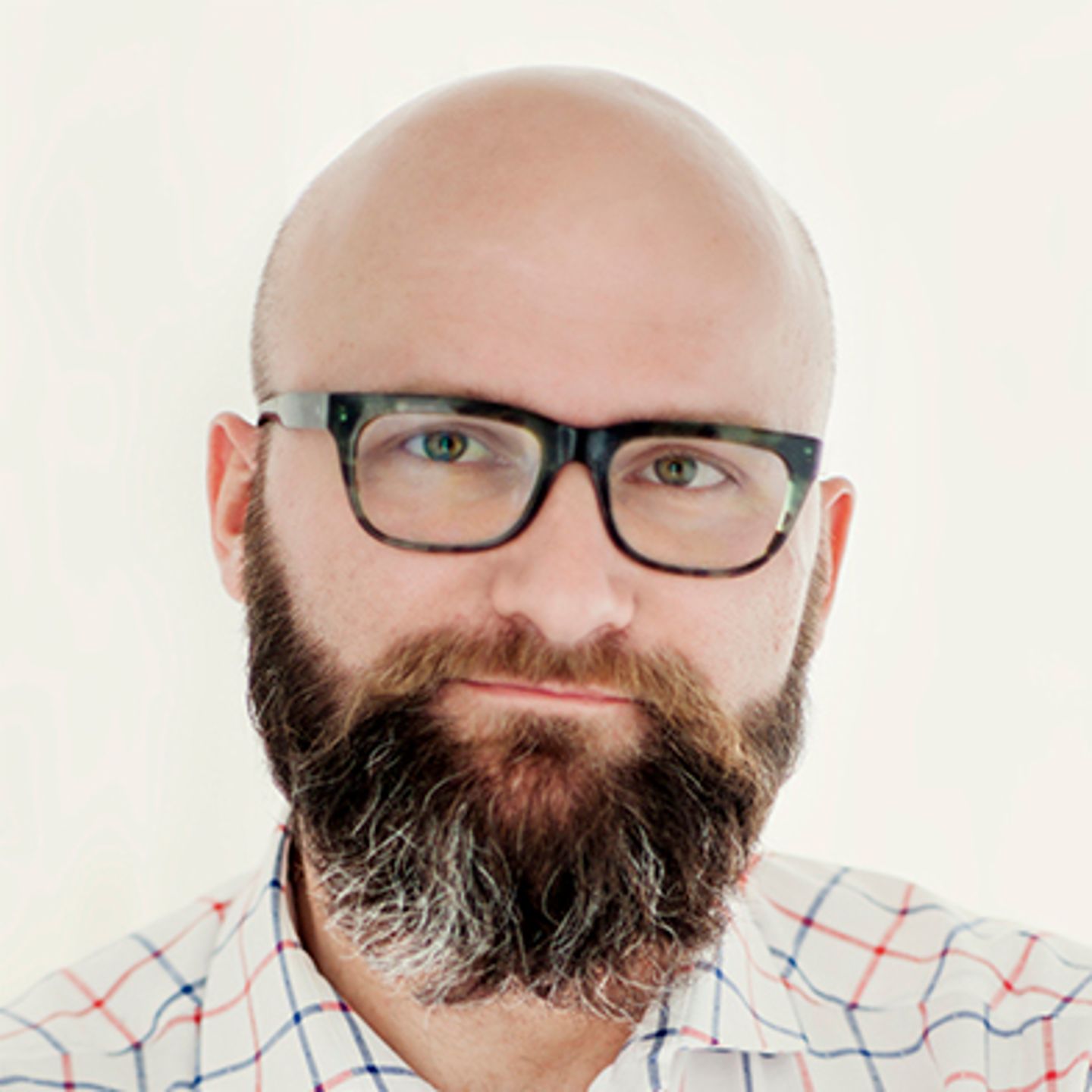 Dr. hab. Tomasz Piekot, portant une chemise à carreaux, s'appuie contre un mur les bras croisés.