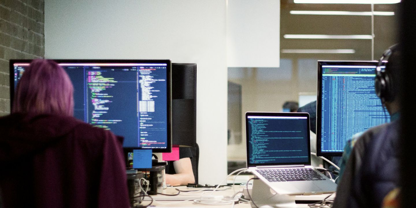 IT security at EOS: People in front of monitors in an office.
