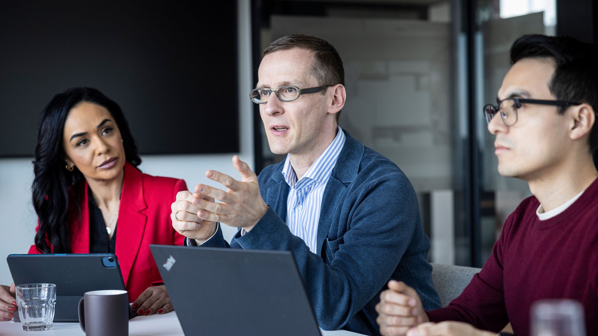 Trois personnes ont une conversation dans un bureau.